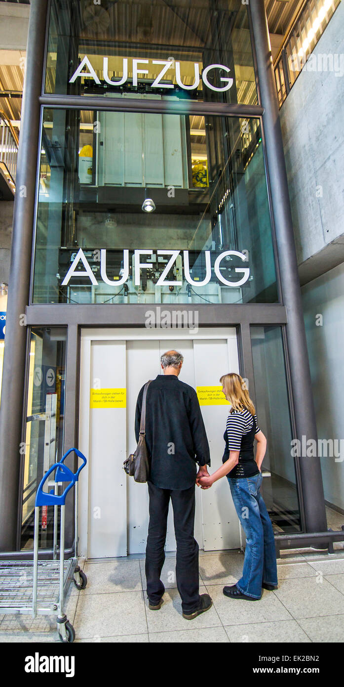 Un couple stand en attente d'un aufzug, un ascenseur, dans un magasin en Allemagne. Banque D'Images