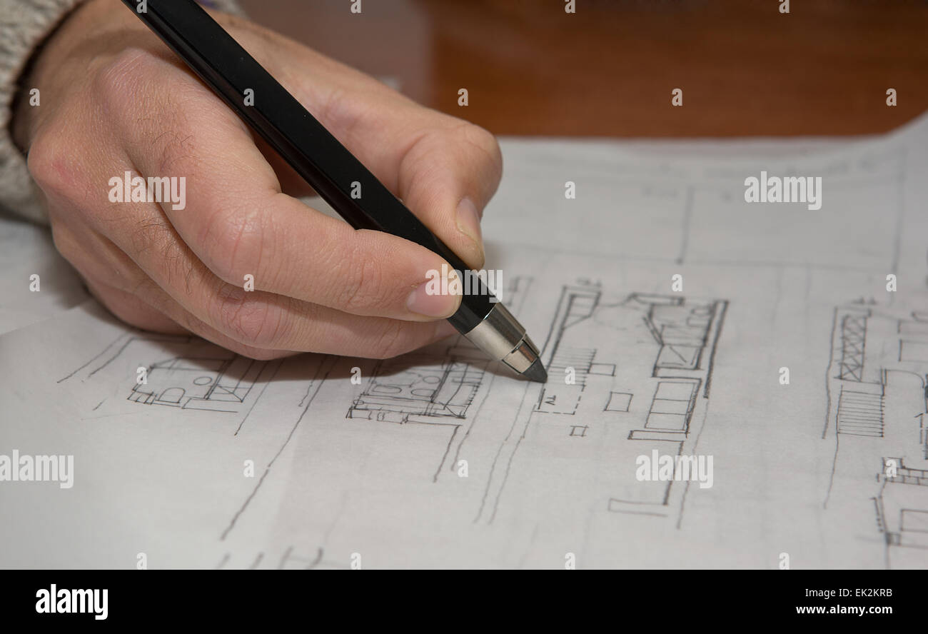 La planification pour la construction de maisons. Architect holding un crayon sur la table Banque D'Images