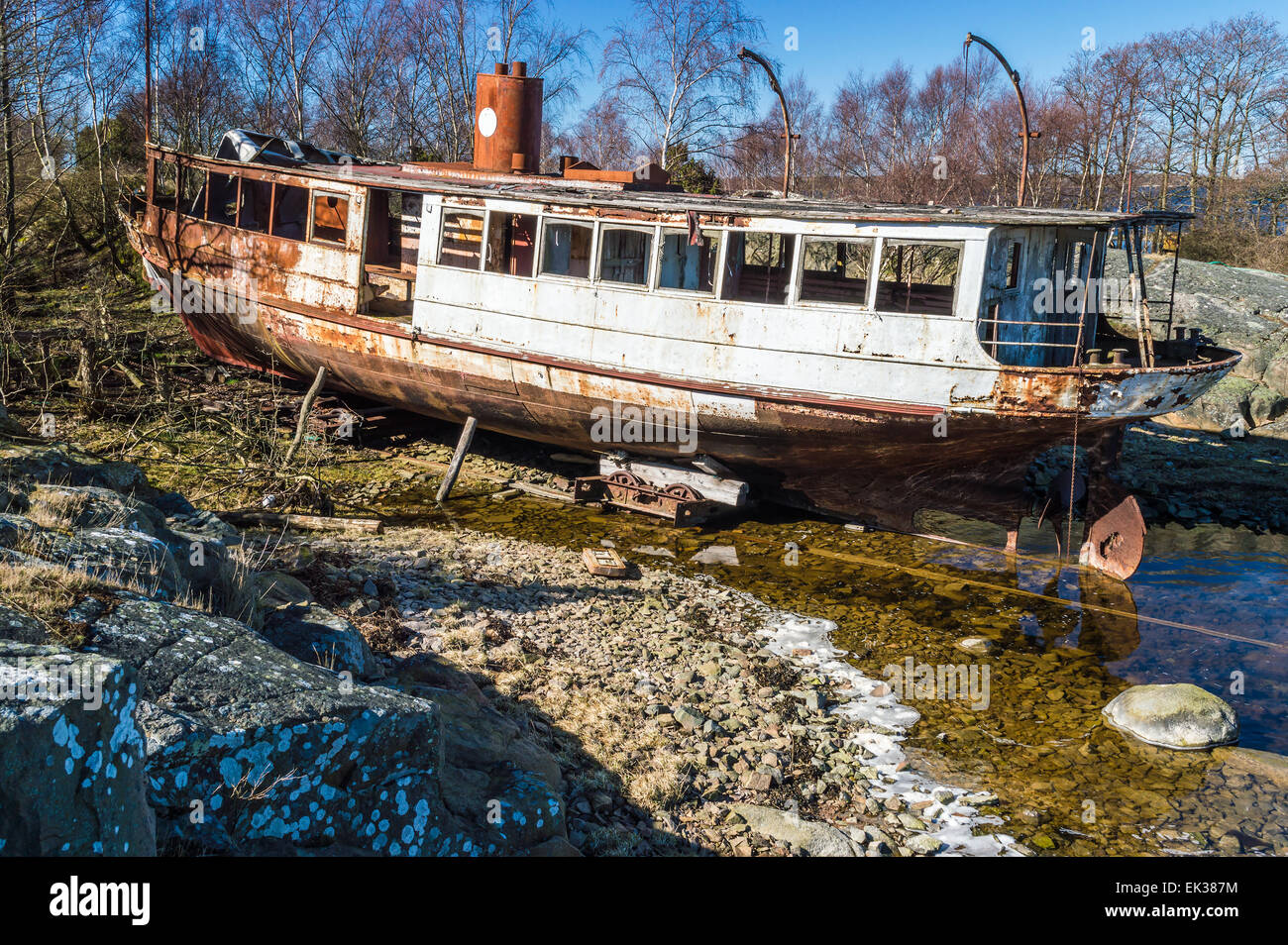 Vieilles et rouillées naufrage tiré hors de l'eau et mis à terre. Épave soutenue par sciage et trolley. C'était une fois par passanger s Banque D'Images