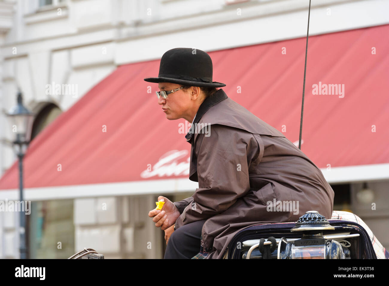 Une femme cocher portant un chapeau melon mange une pomme à Vienne, Autriche  Photo Stock - Alamy