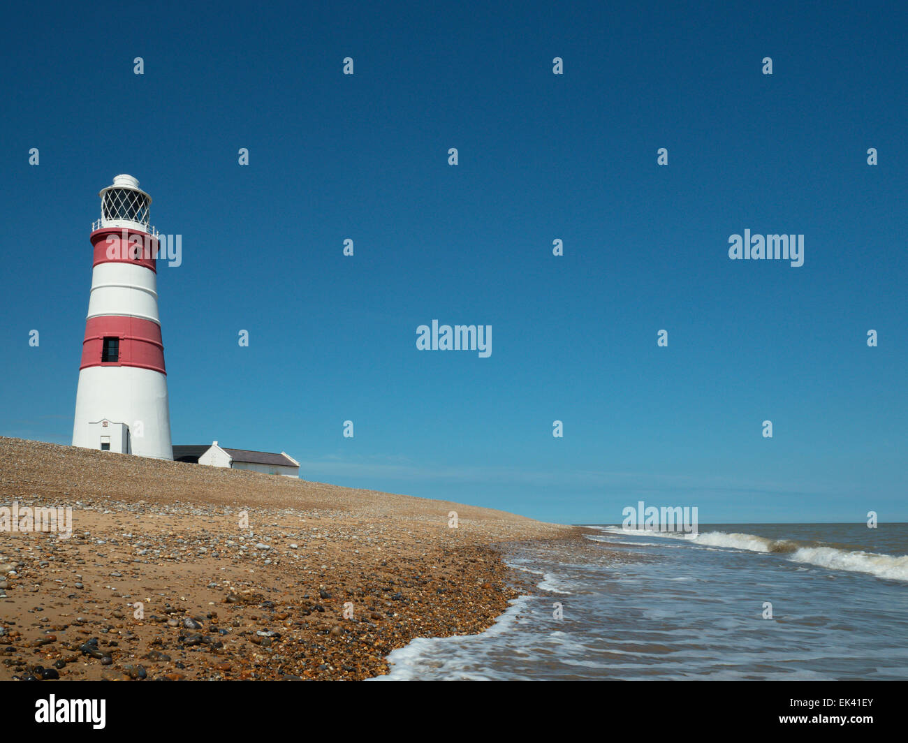 Phare d'Orfordness par temps calme dominant la plage de galets située perileusement près de la mer, Orford Ness, Suffolk, Angleterre, Royaume-Uni Banque D'Images