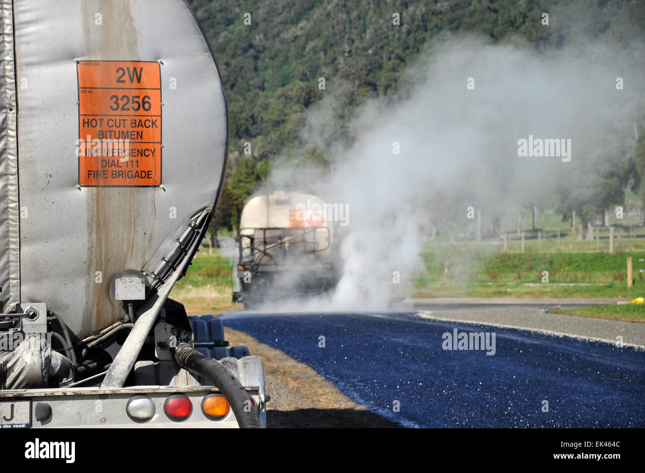 Un pétrolier s'étend du bitume chaud tout en tarsealing une bande d'air privé près de Greymouth, Nouvelle-Zélande Banque D'Images