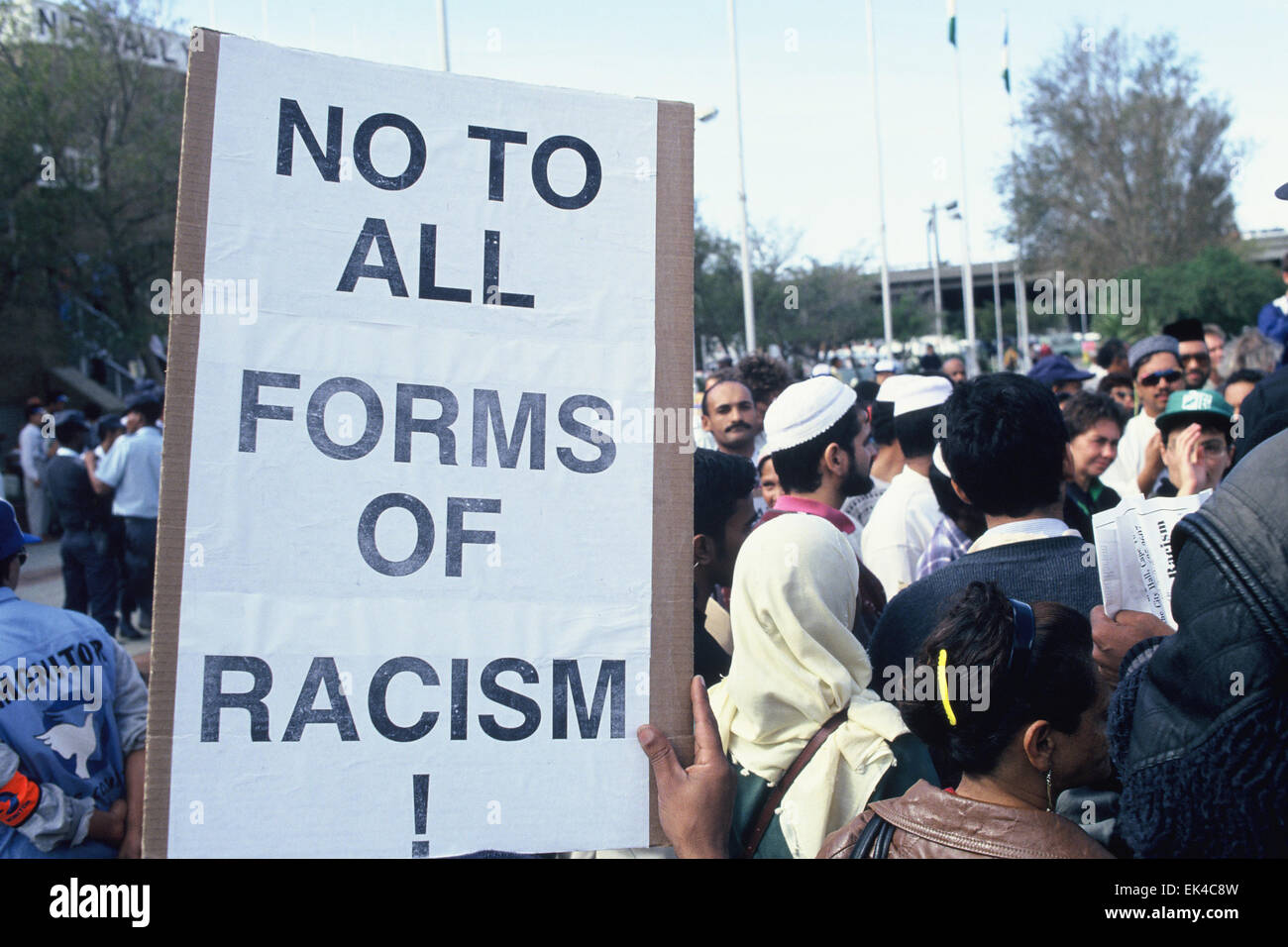 "Non à toutes les formes de racisme" écrit sur une affiche tenu par quelqu'un dans la foule d'attente fièrement pour voter à la première élection démocratique, 27 avril 1994 à l'extérieur de Good Hope Centre, centre ville du Cap.©Sue Kramer Banque D'Images