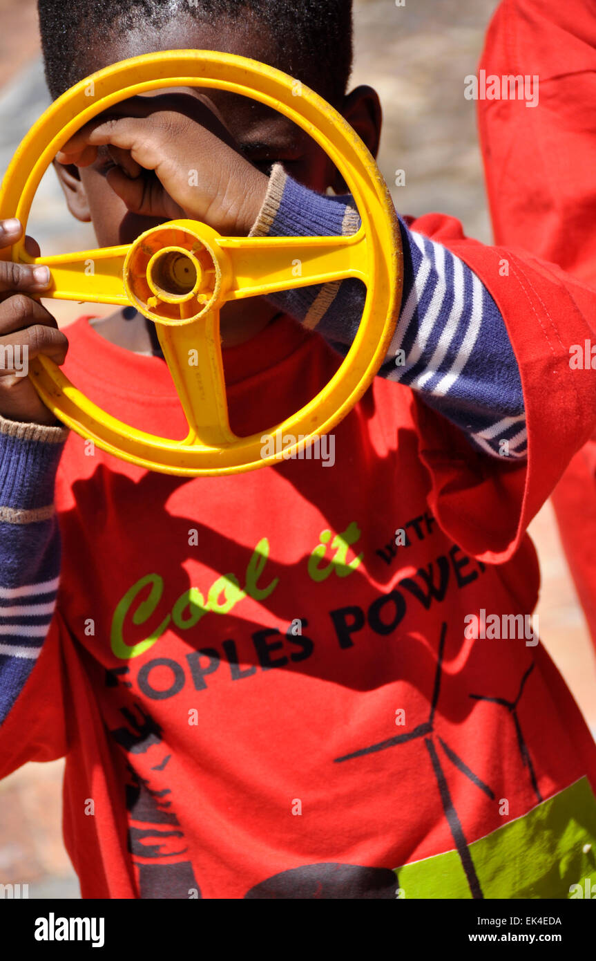 Une façon ludique de l'enfant rend l'appareil photo ou d'un télescope d'hisa volant en habillé en 'cool avec le pouvoir du peuple' T Shirts, 'un million d'emplois climatique à Cape Town's premier Festival d'énergies renouvelables s'est tenue au Parc urbain de GreenPoint, 08.02.2014. Banque D'Images