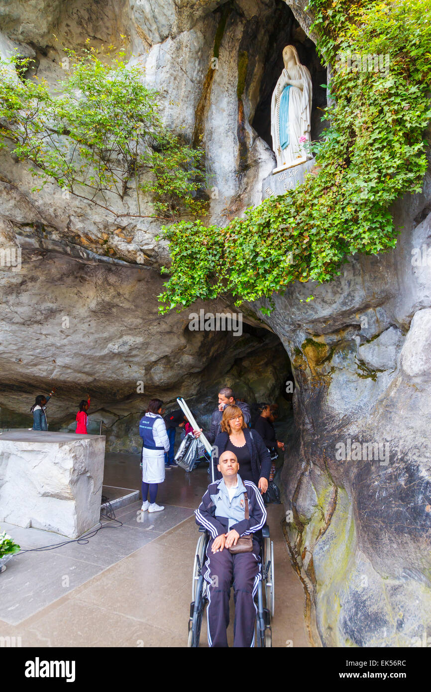 Grotte de Massabielle, statue de Notre Dame de Lourdes et de pèlerins. La ville de Lourdes. Région Midi-Pyrénées, France, Europe. Banque D'Images