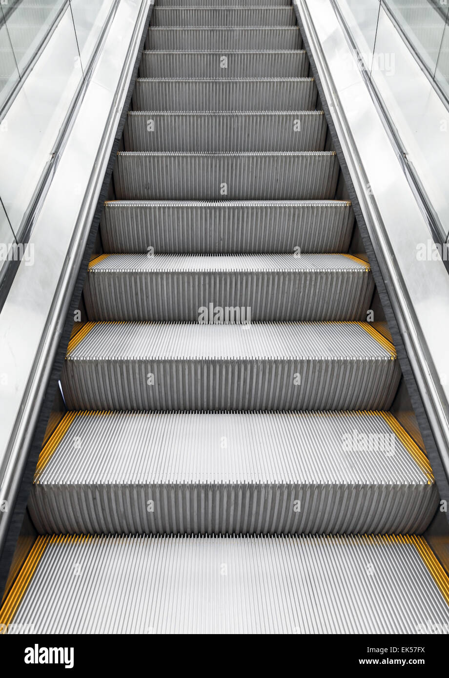 Shining metal escalator remonte, photo verticale avec effet de perspective Banque D'Images