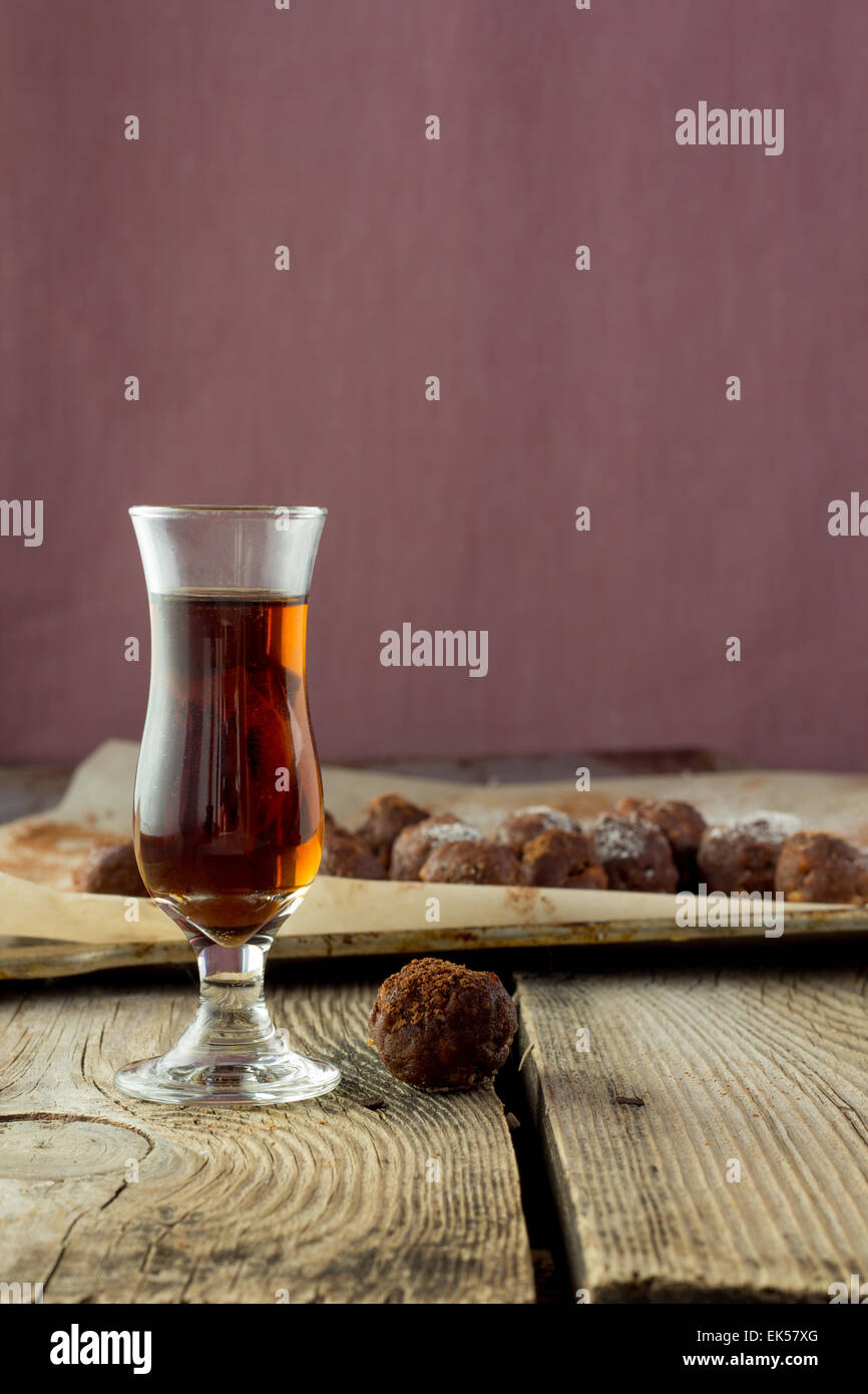 Petit verre de liqueur et des bonbons sur la table en bois Banque D'Images