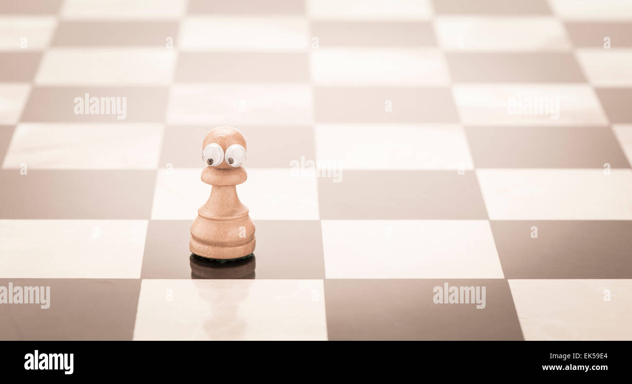 Pièce d'échecs avec les yeux. Image conceptuelle de l'enfance et de la solitude, d'être un enfant solitaire et d'inquiétude. Banque D'Images