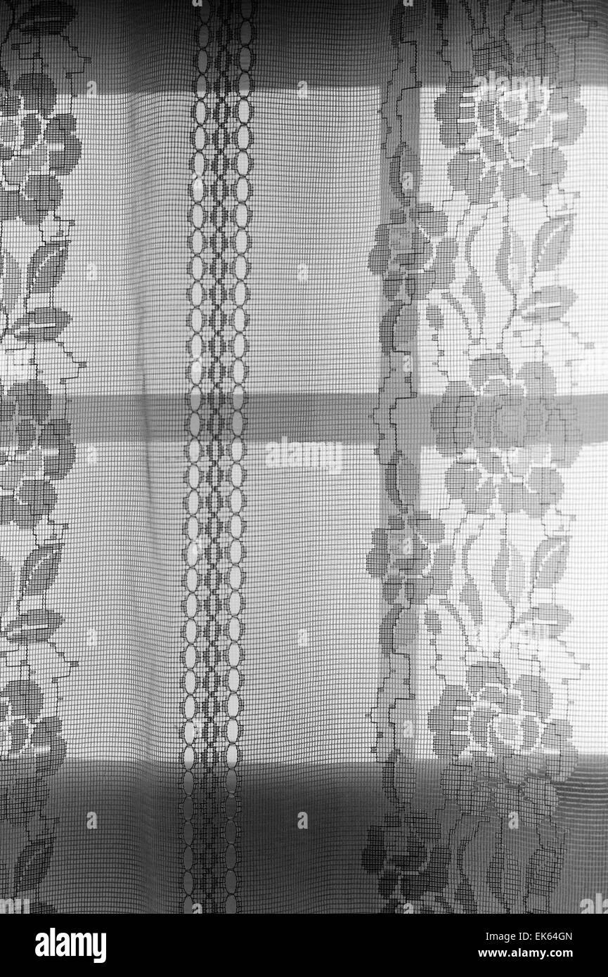 Noir & blanc, de rideau de dentelle rétro-éclairé par le soleil couchant Banque D'Images