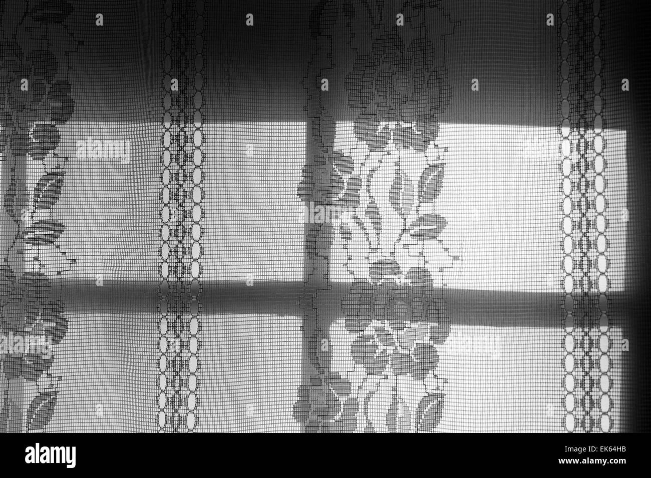 Noir & blanc, de rideau de dentelle rétro-éclairé par le soleil couchant Banque D'Images