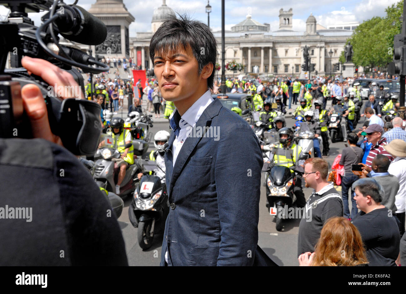 Londres, Angleterre, Royaume-Uni. Les chauffeurs de taxi noir différend, 2014, présentateur de télévision japonais faisant une diffusion à l'extérieur Banque D'Images