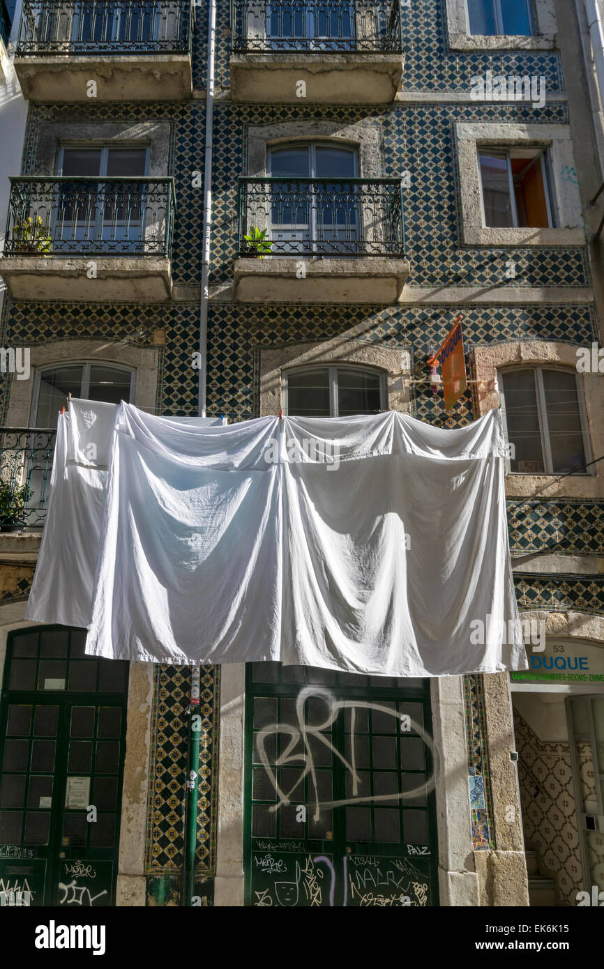 Lisbonne Portugal les draps de lit accroché pour sécher à l'extérieur d'un bâtiment ancien sol carrelé DANS LE CENTRE DE LA VILLE Banque D'Images