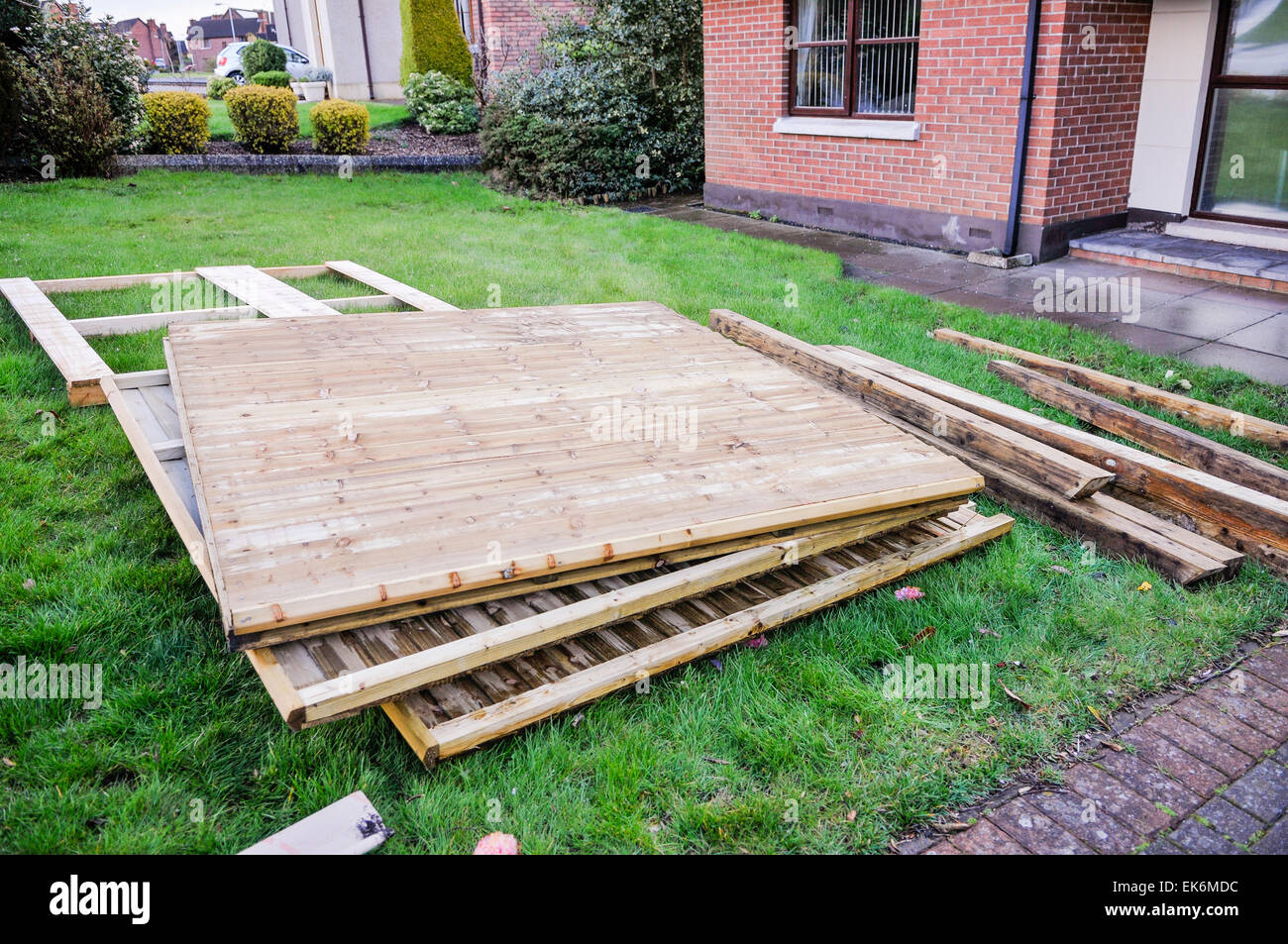 Postes et des panneaux de clôture livrée sur la pelouse à l'avant d'une maison Banque D'Images