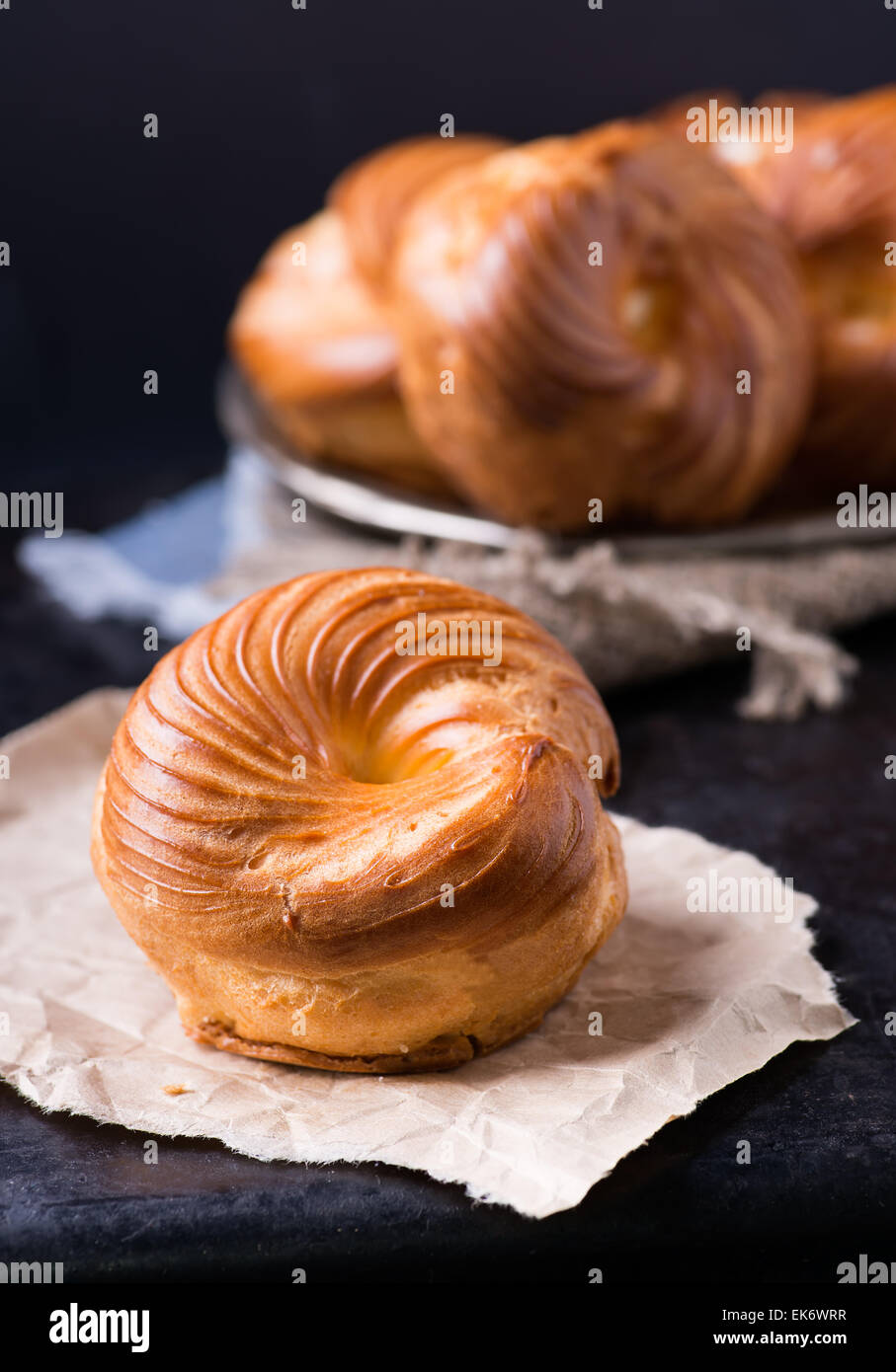 Pâte à choux crème pâtissière avec anneau eclair sur fond sombre, selective focus Banque D'Images