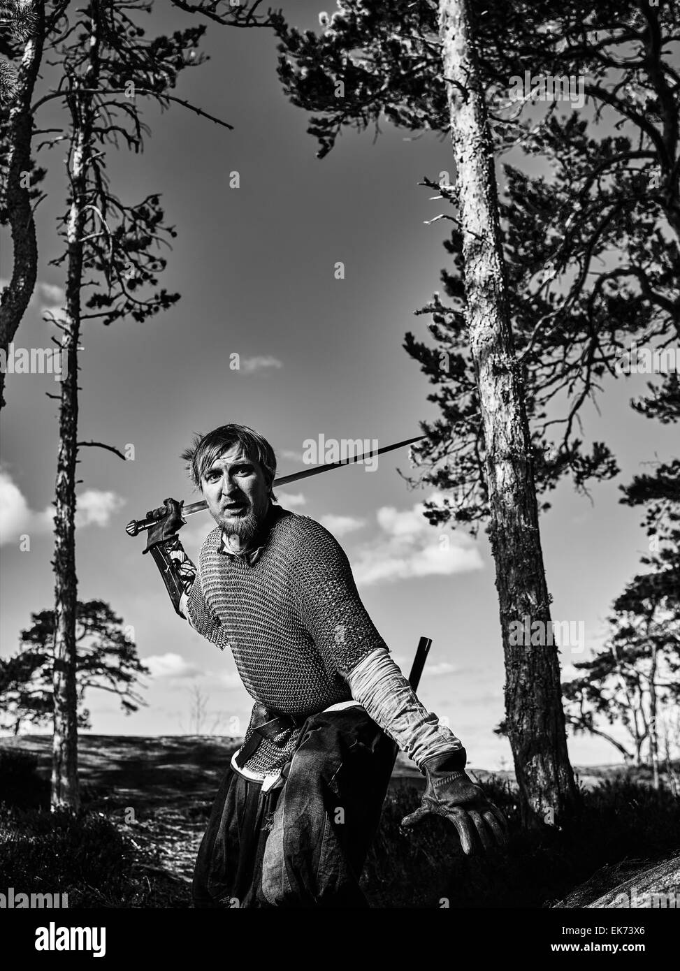 Guerrier viking médiéval portant cotte et il a l'épée, sur la nature du fond, image en noir et blanc Banque D'Images
