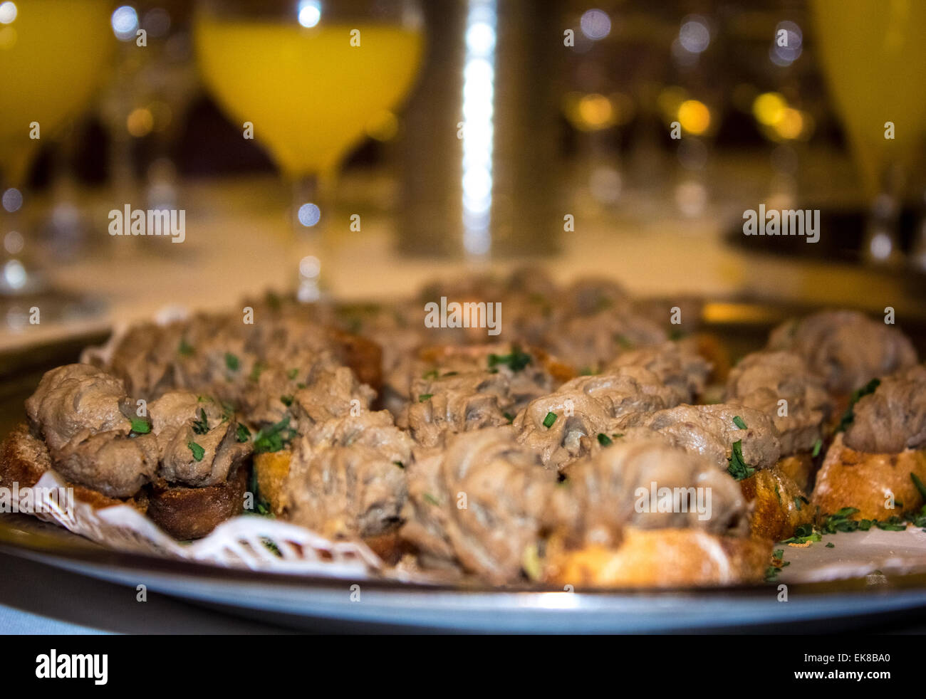 Pain, coller et ciboulette salés canapés sur un plateau en face de certains jus d'orange et de Bucks Fizz à lunettes dans un espace VIP. Banque D'Images