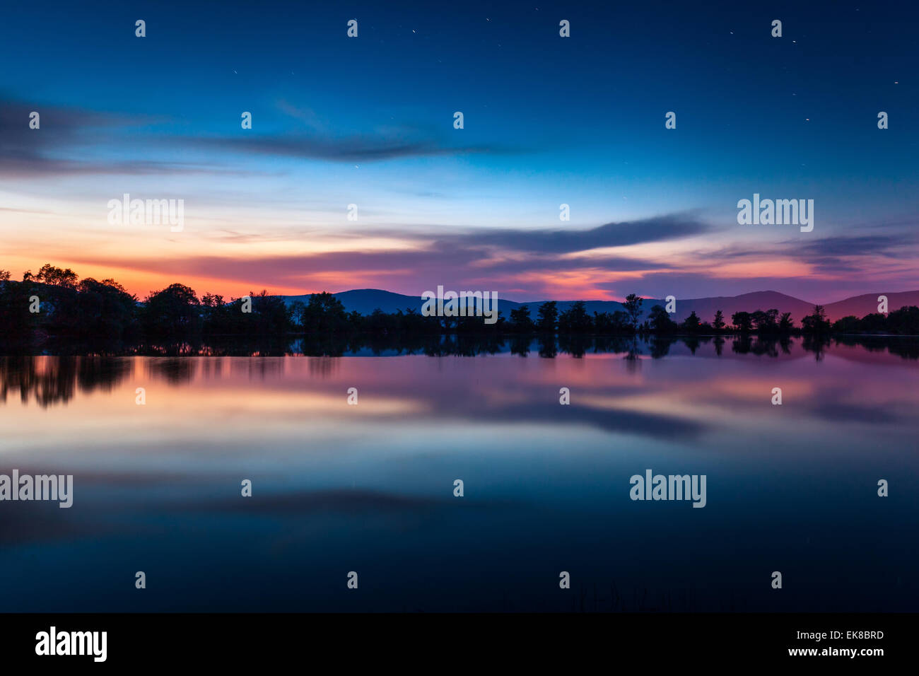 Belle nuit de printemps sur l'étang avec des étoiles, des nuages et de réflexion en Crimée Banque D'Images