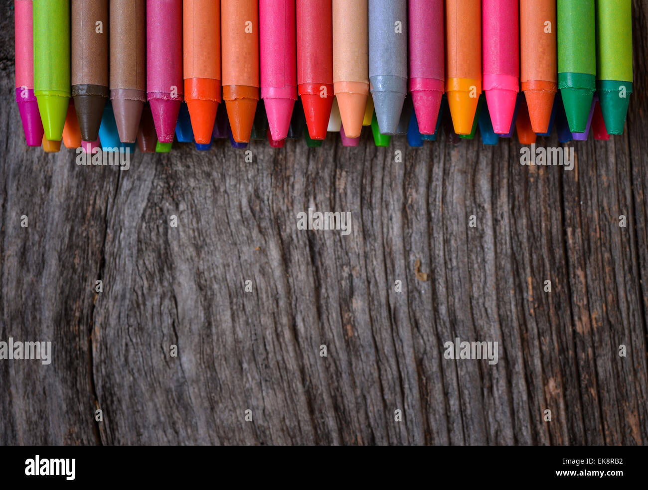Des crayons alignés sur fond de bois Banque D'Images