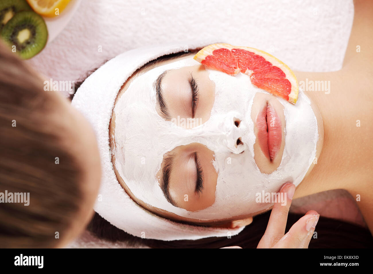 Jolie jeune femme avec un masque de fruits sur un visage Banque D'Images