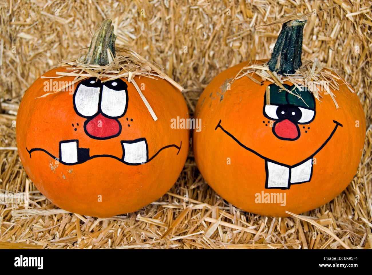 Paire de citrouilles sur une balle de foin avec funny faces peintes. Banque D'Images