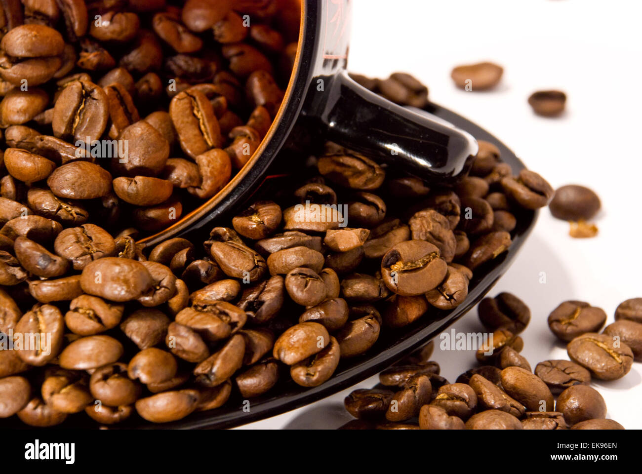 Tasse et soucoupe avec les grains de café isolated on white Banque D'Images