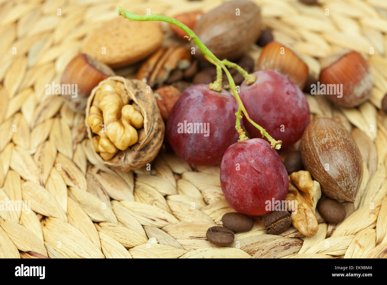 Les noix et raisins sur un tapis en osier Banque D'Images