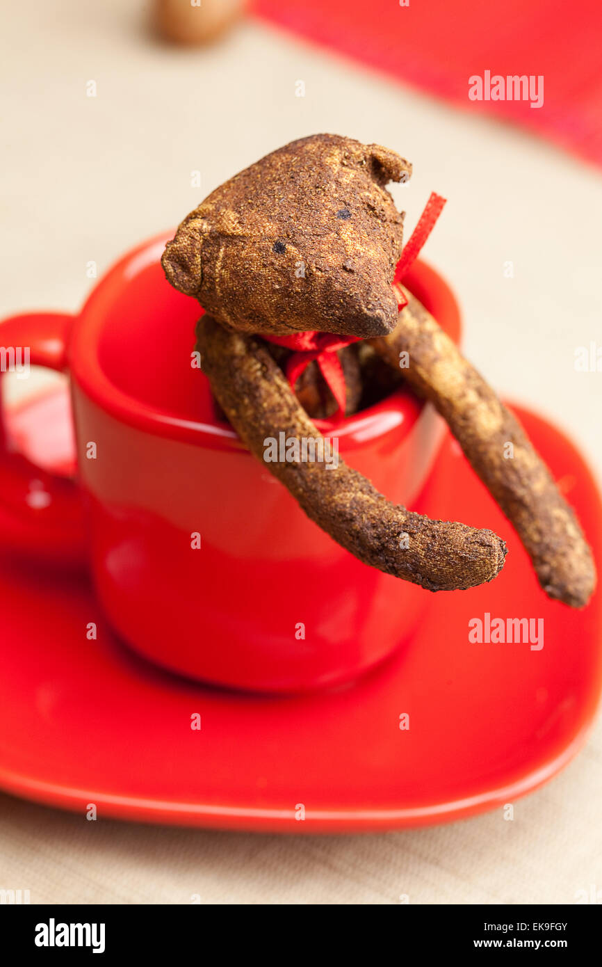 Ours en peluche à la main dans un tasse et écrous Banque D'Images