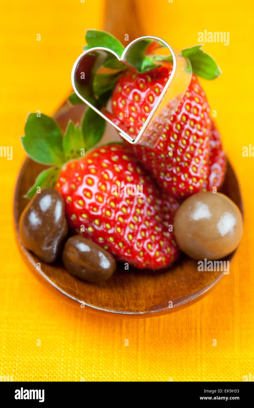 Fraise, coeurs et Bonbons au chocolat dans la cuillère en bois de th Banque D'Images