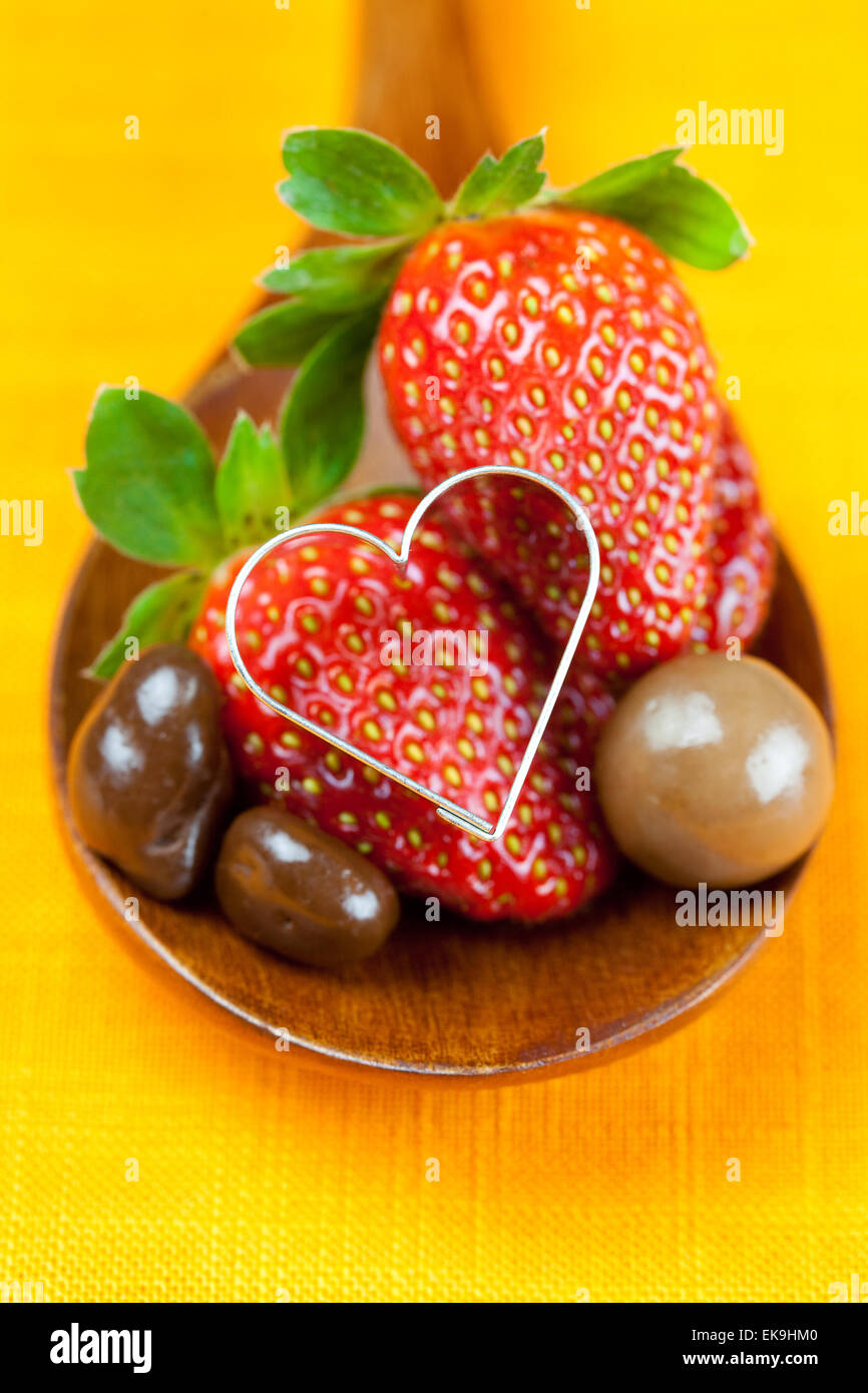 Fraise, coeurs et Bonbons au chocolat dans la cuillère en bois de th Banque D'Images