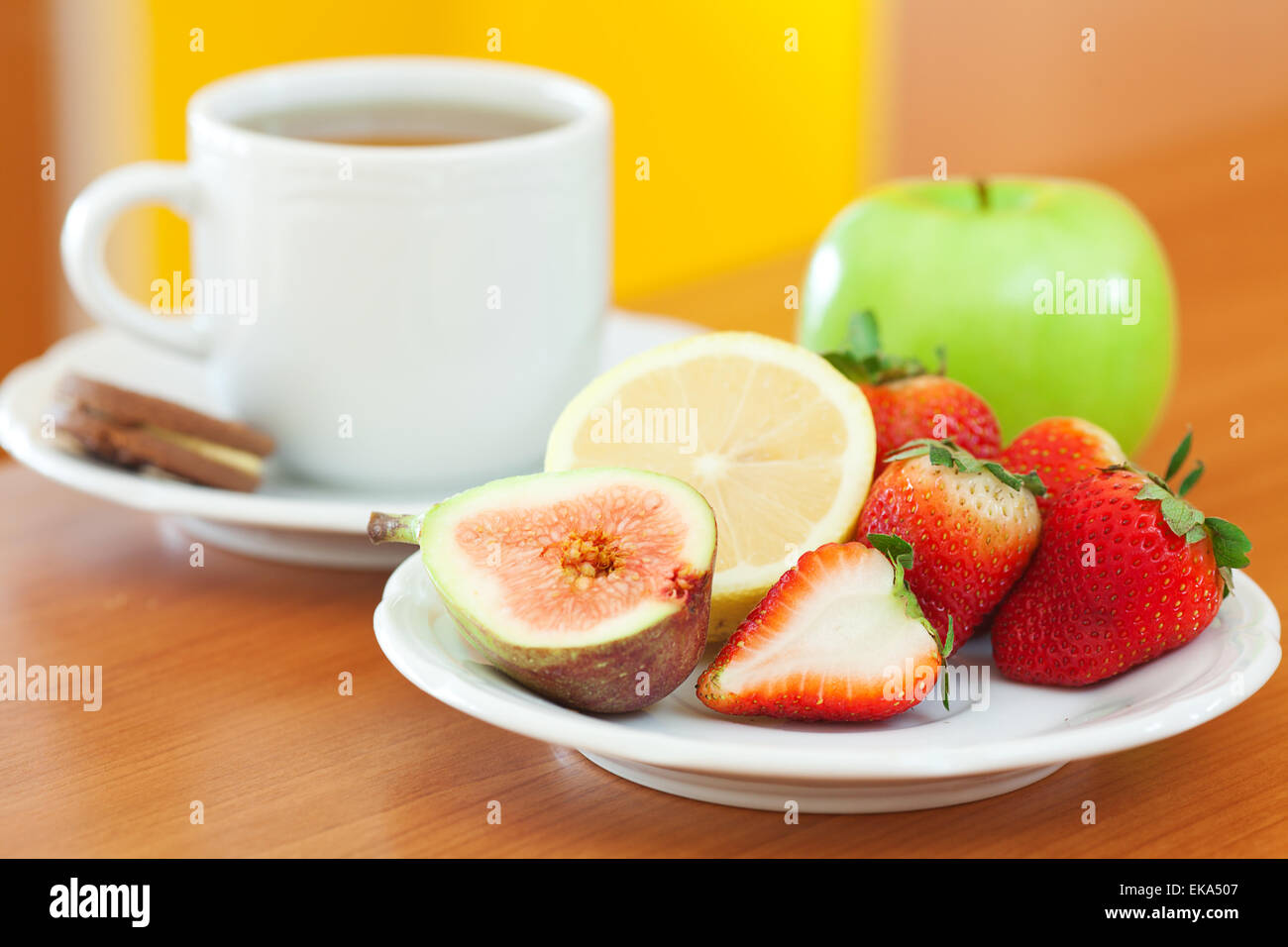 Tasse de thé,cookie,pomme, citron, figues et fraises sur une plaque Banque D'Images