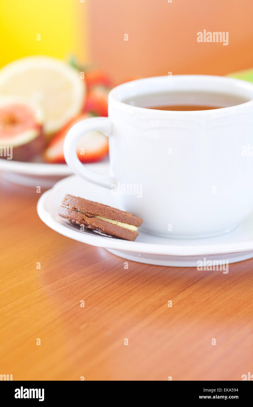 Tasse de thé,cookie,pomme, citron, figues et fraises sur une plaque Banque D'Images