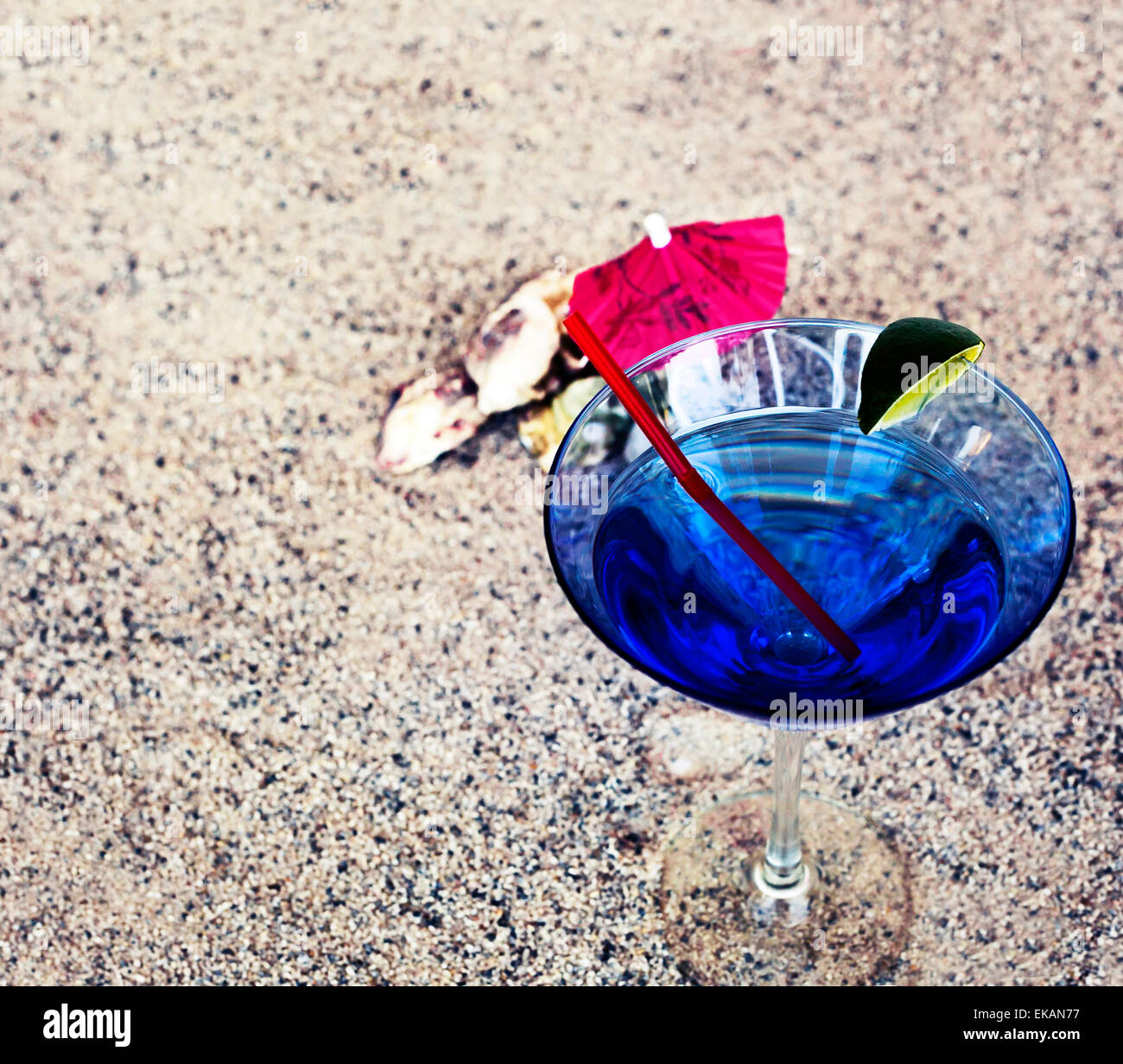 Fond de plage avec du sable de plage, rythme copie thème d'été, verre à cocktail avec parasol et une paille sur la texture du sable Banque D'Images