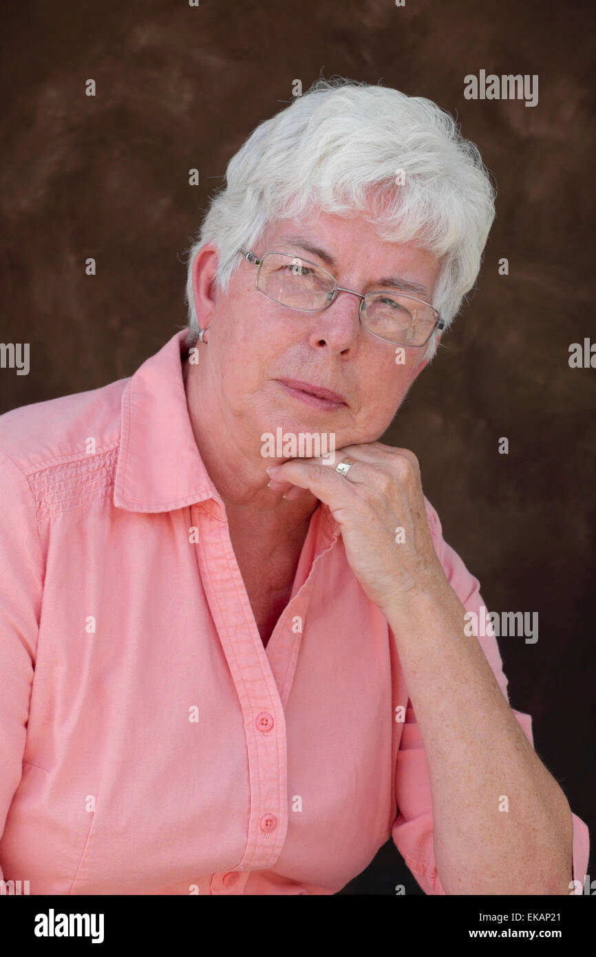 Certains aînés, femme aux cheveux blancs se penche sur l'appareil photo. Banque D'Images