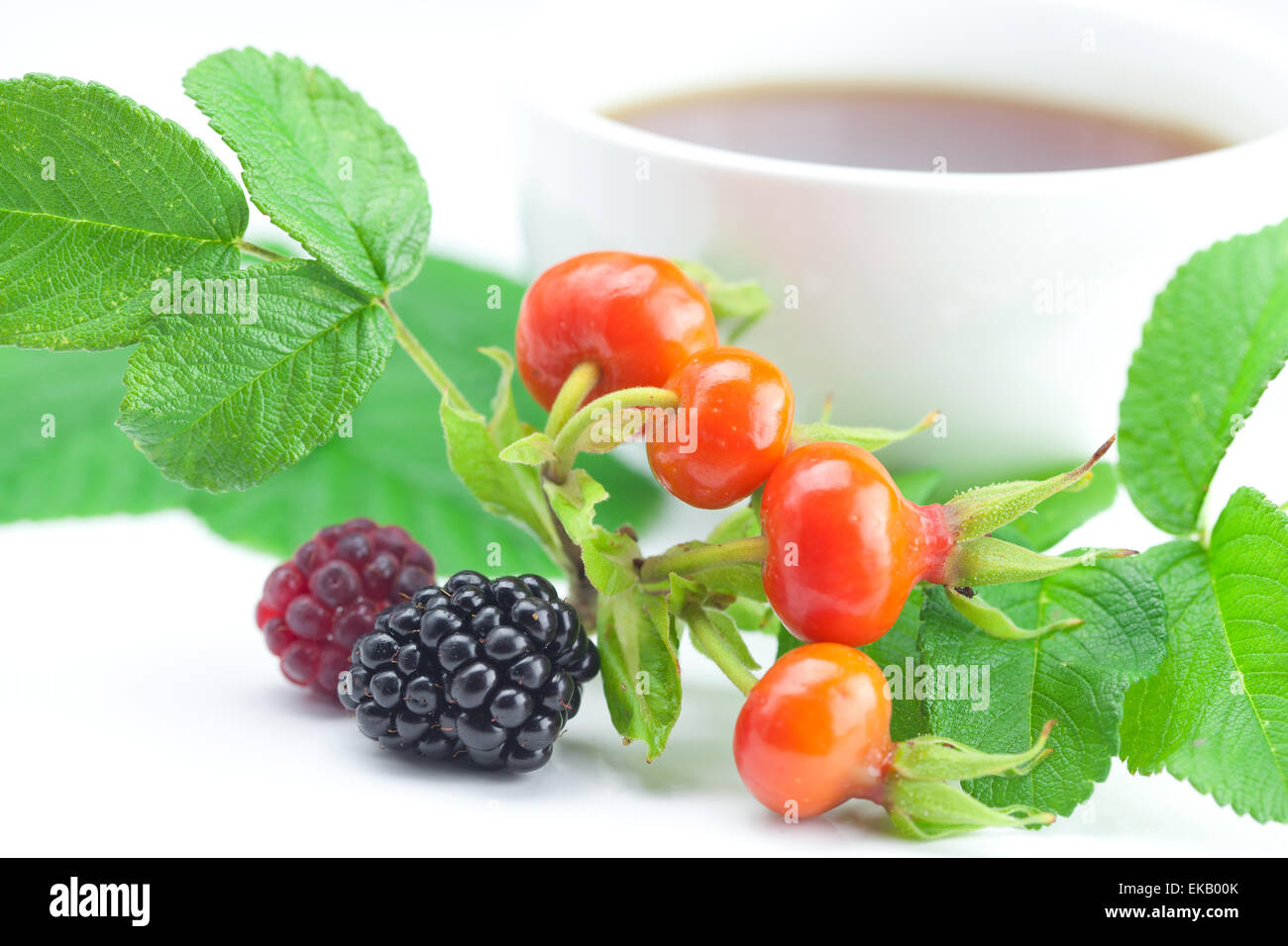 Tasse de thé, blackberry,framboise et fruits de rose musquée avec feuilles Banque D'Images