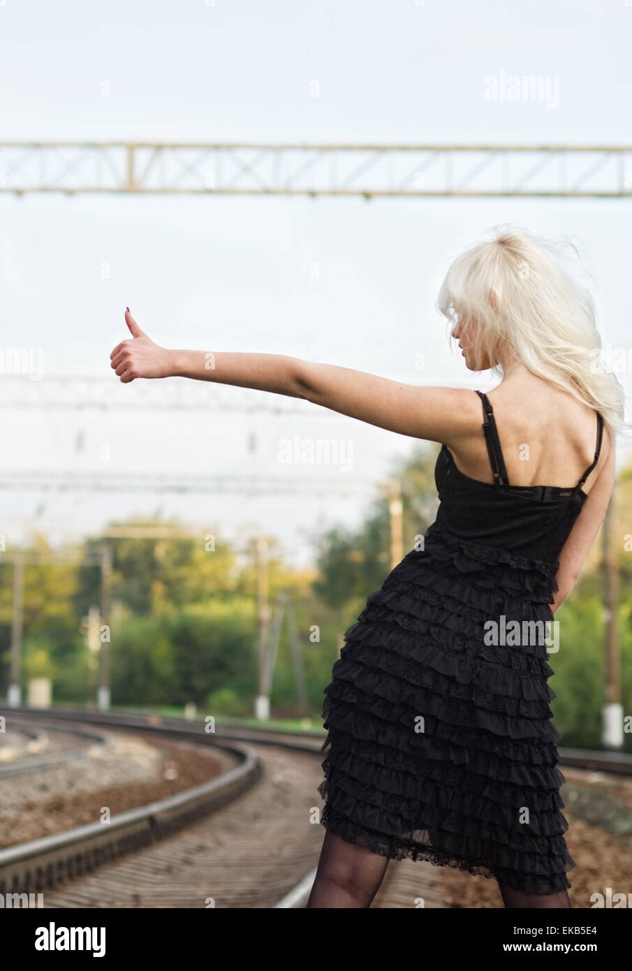 Jeune fille sexy est l'auto-stop sur un chemin de fer. Vue arrière Banque D'Images
