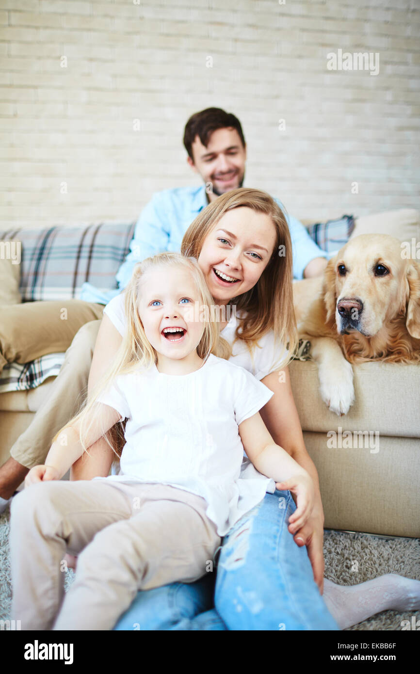 Happy female et petite fille rire avec le chien et le jeune homme sur l'arrière-plan Banque D'Images