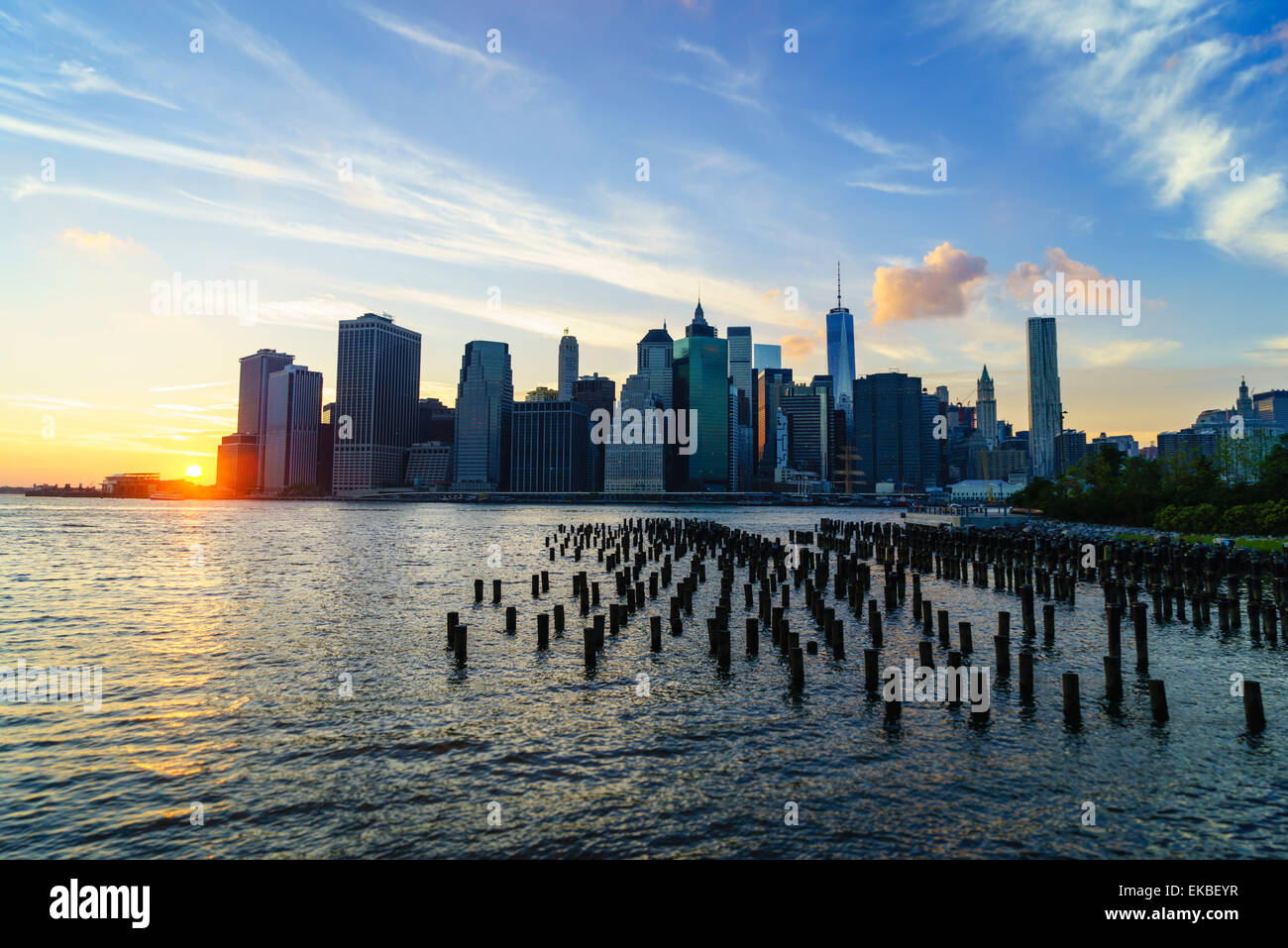 Lower Manhattan skyline at sunset, le reste de l'ancien entrepôt pilots dans l'avant-plan, New York, États-Unis d'Amérique Banque D'Images