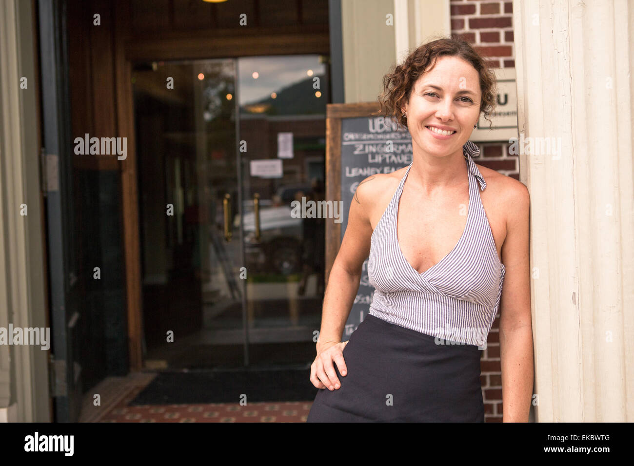 Portrait de femme shop keeper en porte de petit magasin Banque D'Images
