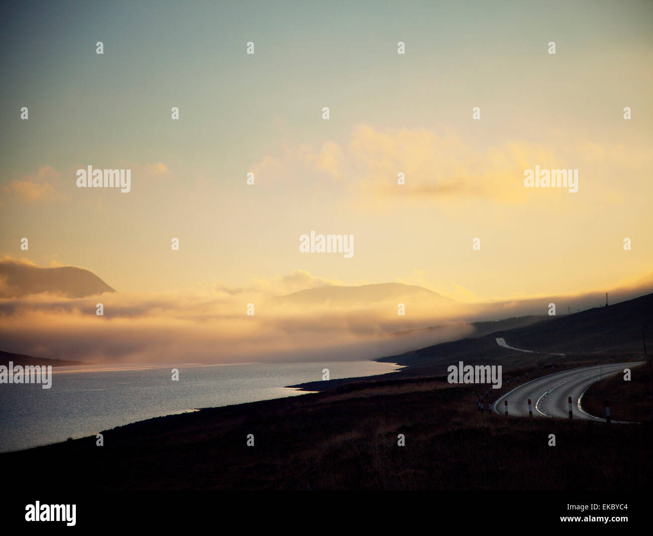 Vue sur route sinueuse et loch au crépuscule, North West Highlands, Ecosse, Royaume-Uni Banque D'Images
