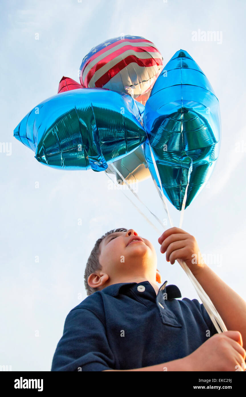 Boy holding balloons Banque D'Images