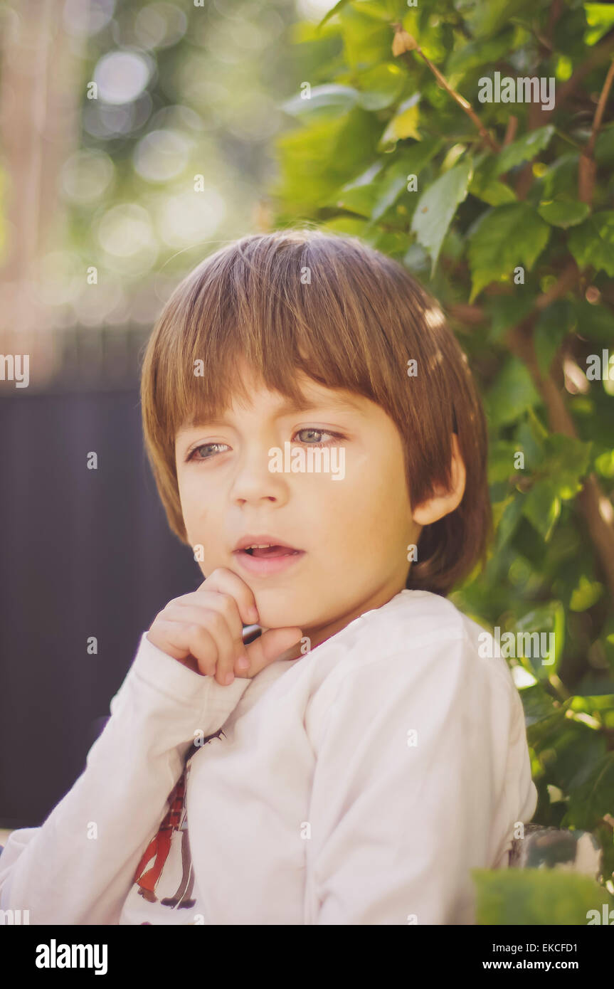 Portrait d'un garçon avec un main sur son menton Banque D'Images