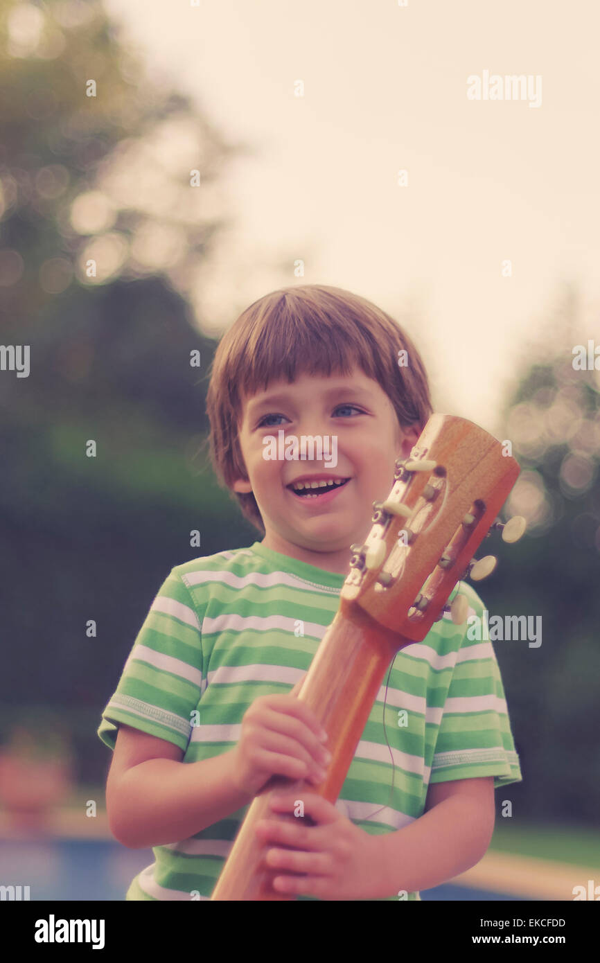 Smiling boy holding a guitar Banque D'Images