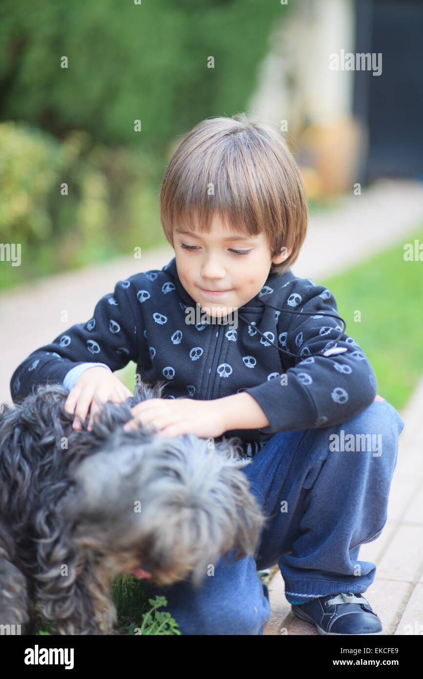 Jeune garçon jouant avec un chien Banque D'Images