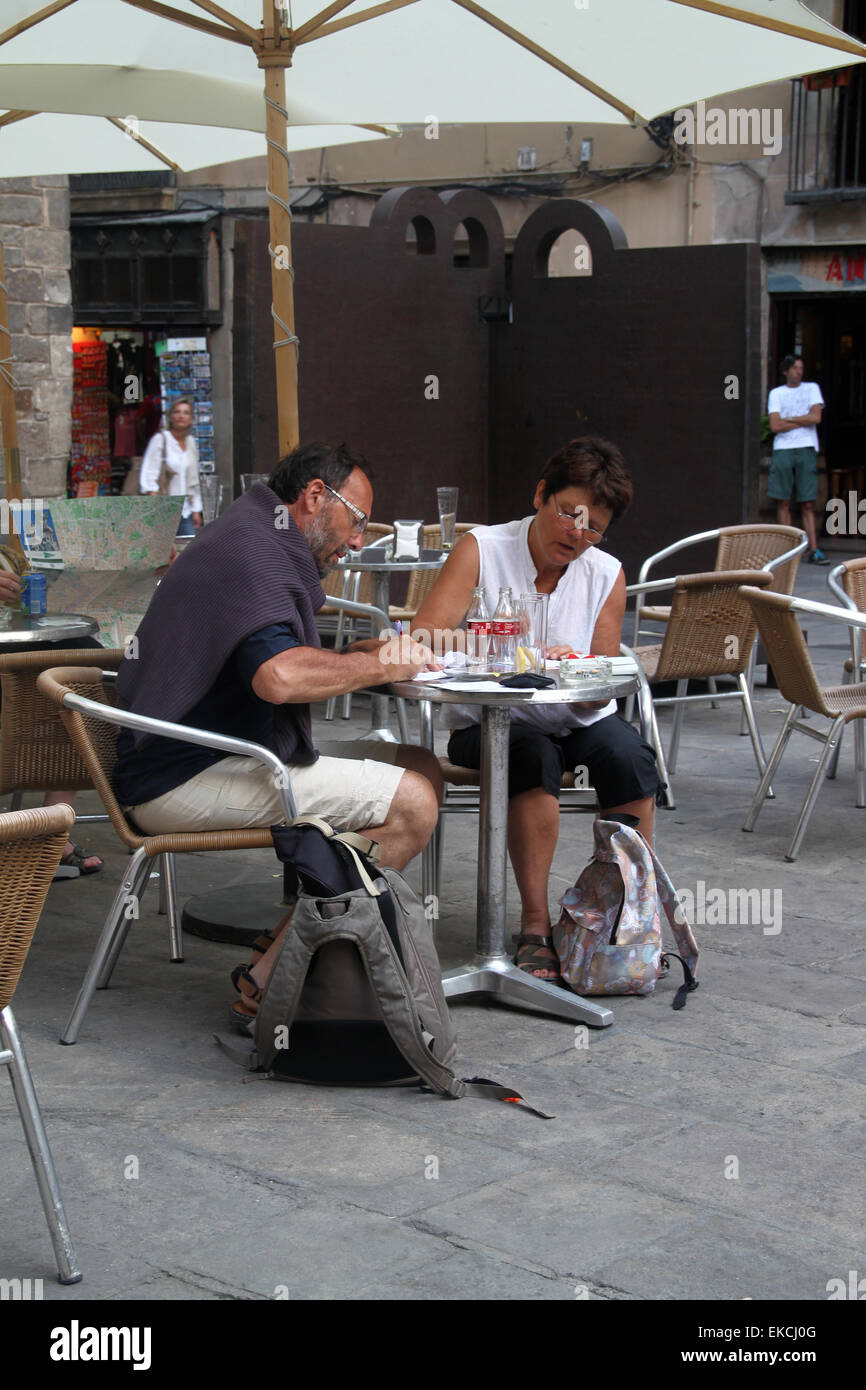 Deux touristes l'écriture des cartes postales et assis à un café en plein air dans le quartier gothique de Barcelone, Catalogne, Espagne Banque D'Images