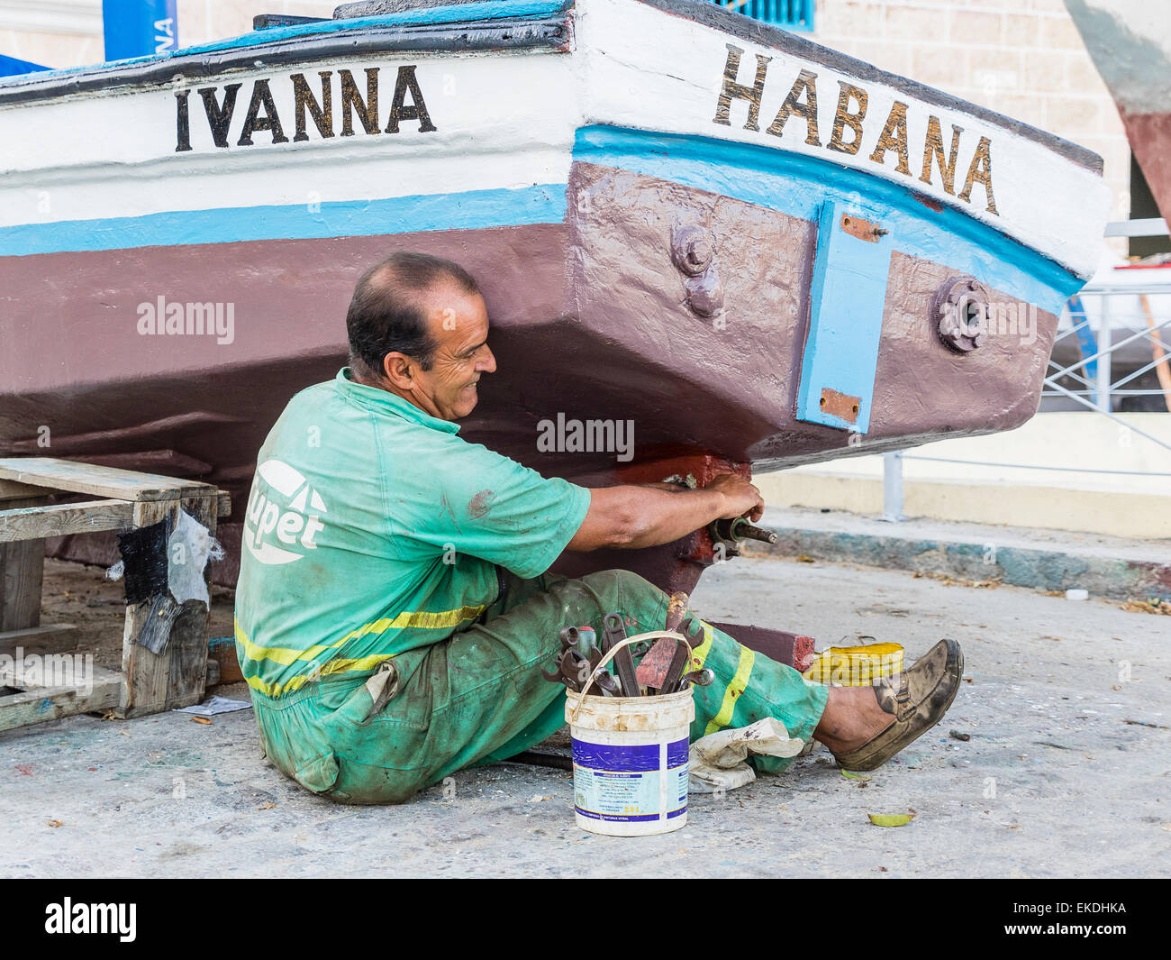 Un moyen-âge Cuban homme est assis sur le sol comme il répare l'hélice sur  son bateau à La Havane, Cuba Photo Stock - Alamy