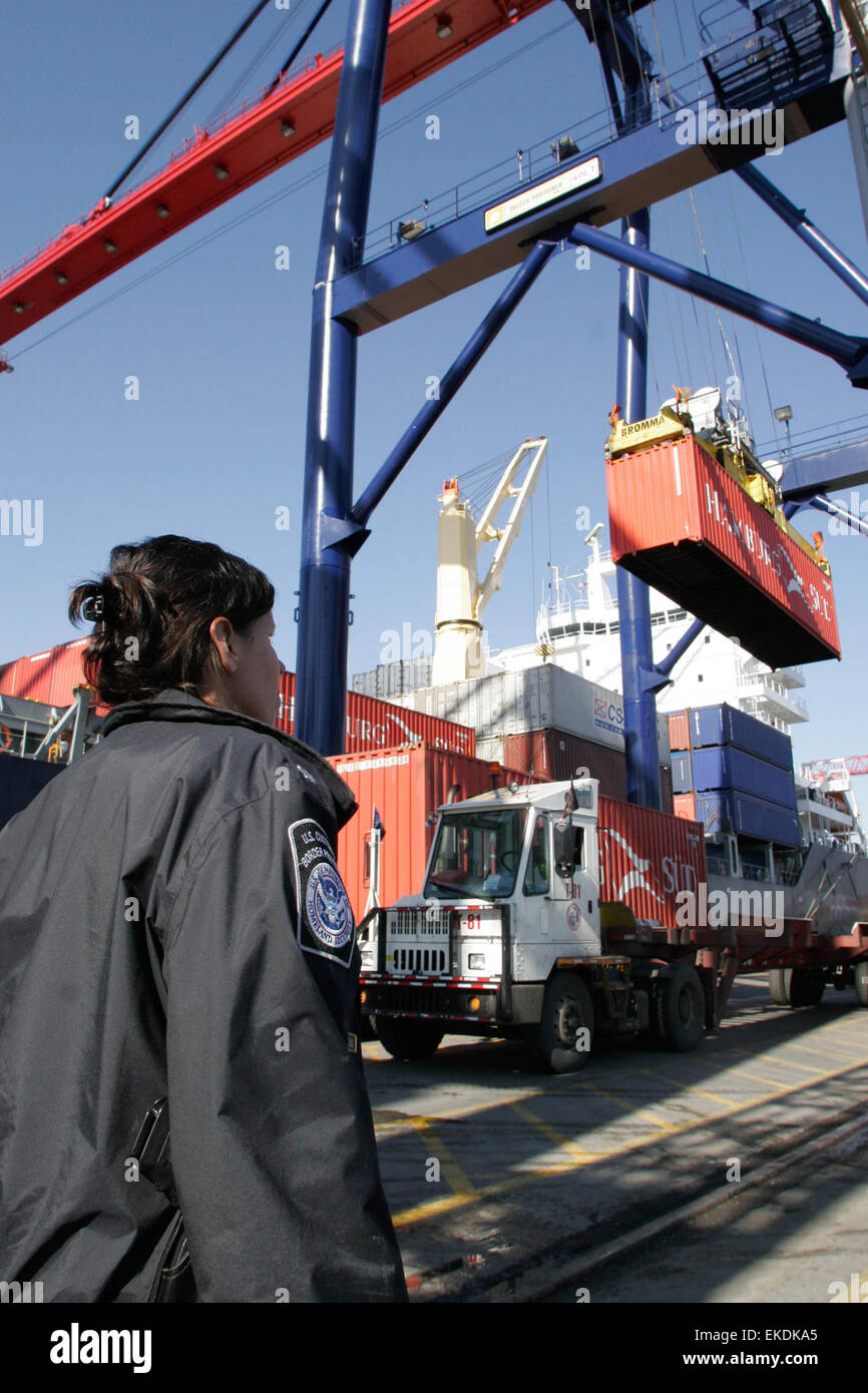 Au port maritime de Newark, dans le New Jersey, un officier du CBP supervise l'opération lorsqu'un conteneur maritime est chargé sur un camion pour le transport. Cela garantit que la cargaison est conforme aux règlements douaniers américains et aux protocoles de sécurité. Banque D'Images