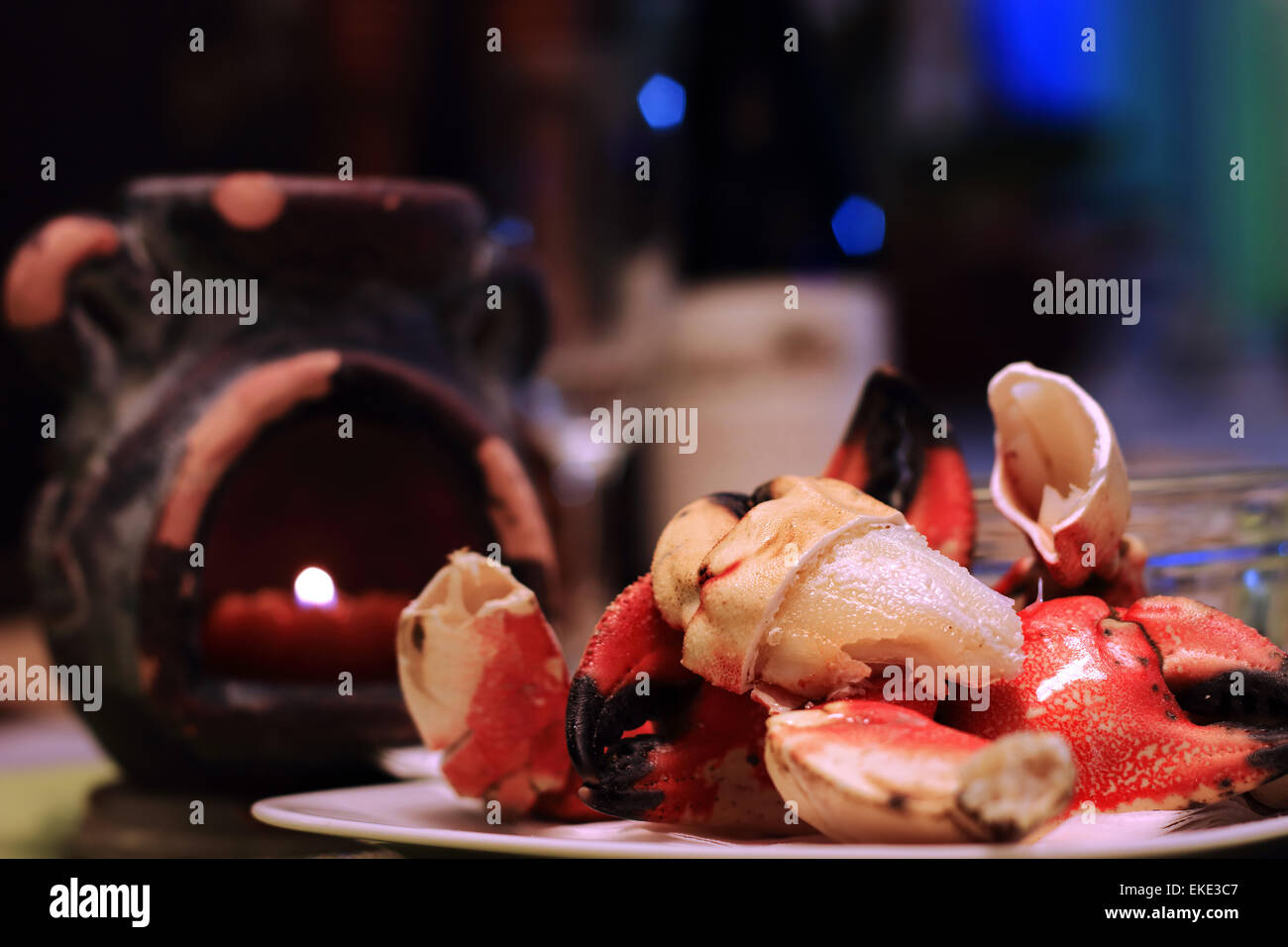 Pinces de crabe Jonah crevassées, montrant la viande succulente sur une assiette, avec la lumière de bougie et defocsed en verre de vin restauration resta Banque D'Images
