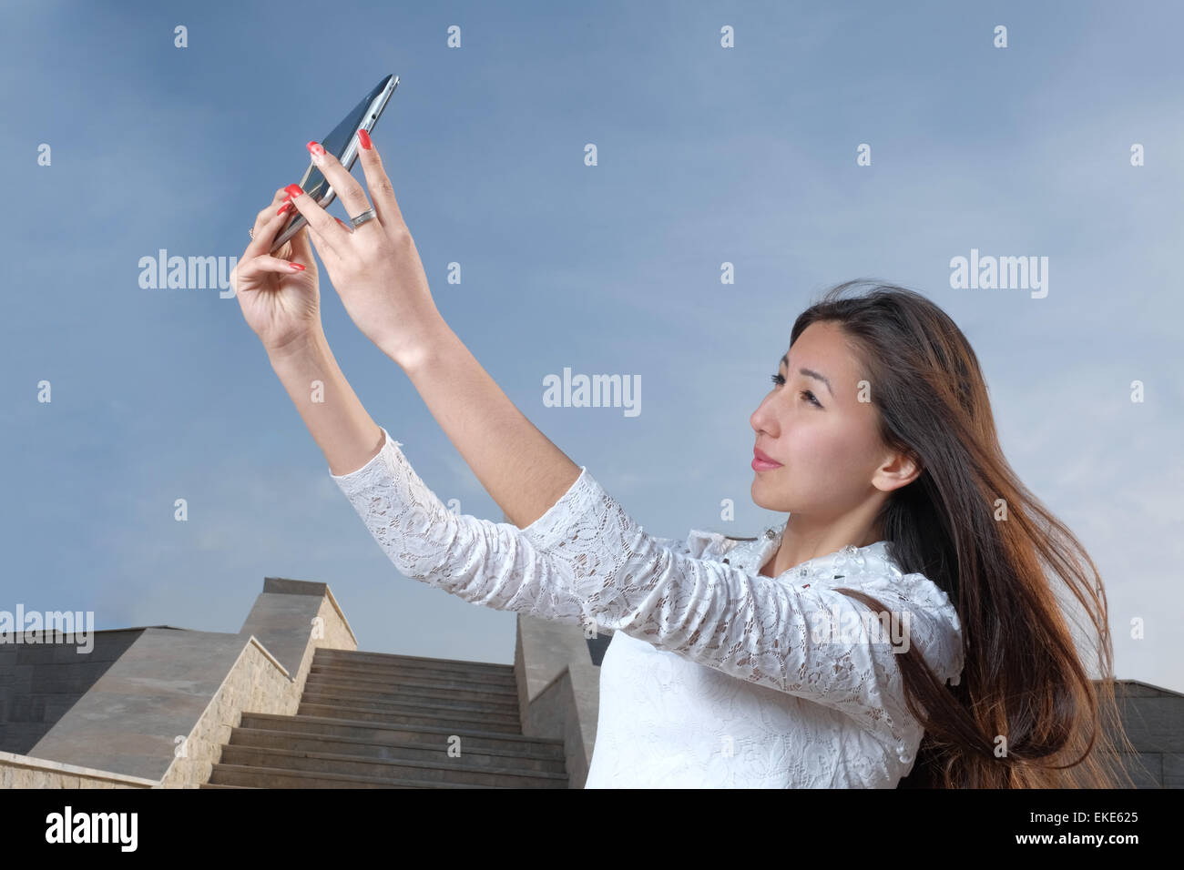 Les jeunes femmes japonaises aux cheveux longs n'afainst selfies city park en étapes et ciel bleu clair avec la lumière de brume, copyspace sur le ciel Banque D'Images