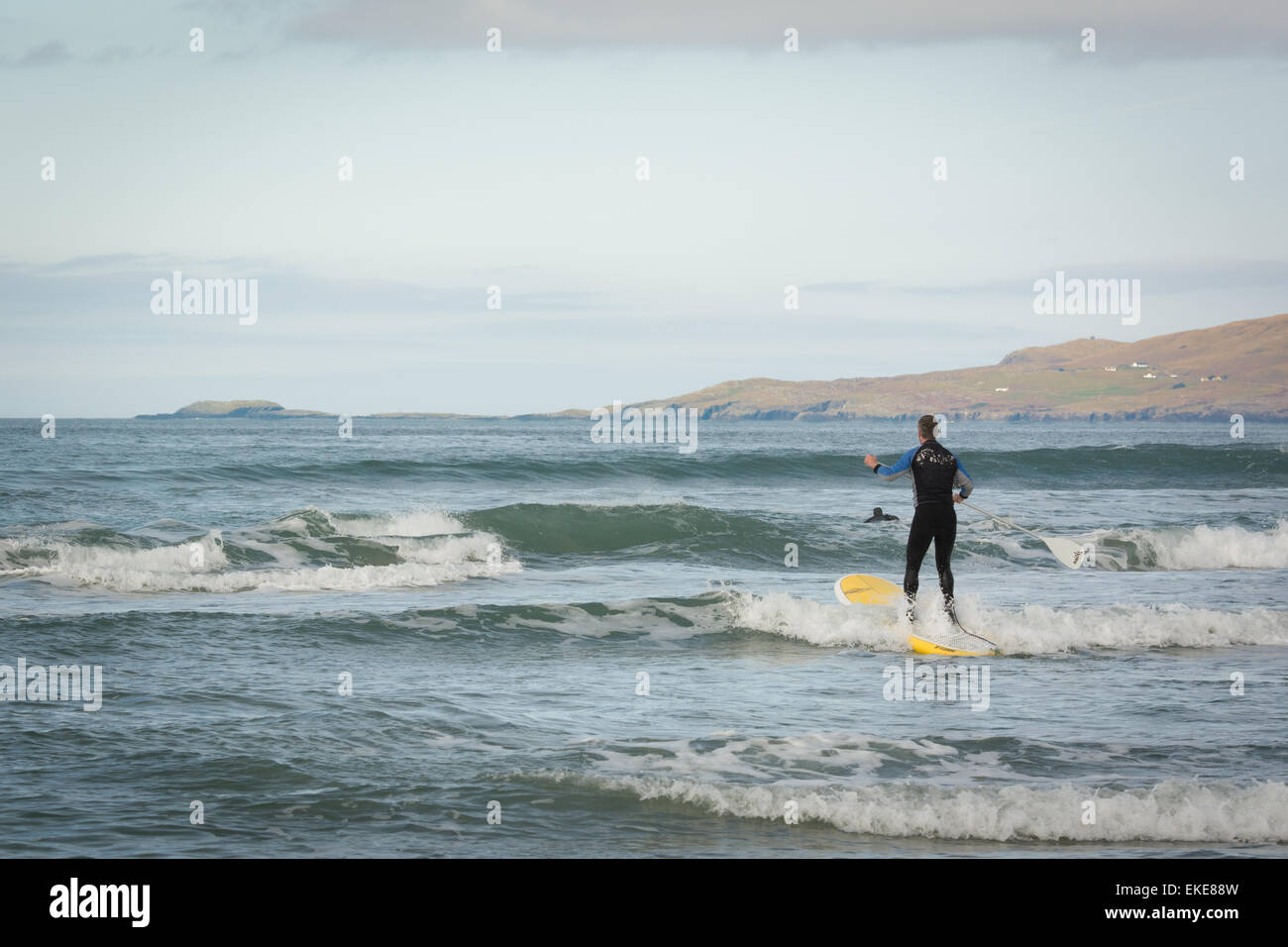 Man paddleboarding dans la mer au large de Mayo le long de la manière sauvage de l'Atlantique sur la côte ouest de l'Irlande Banque D'Images