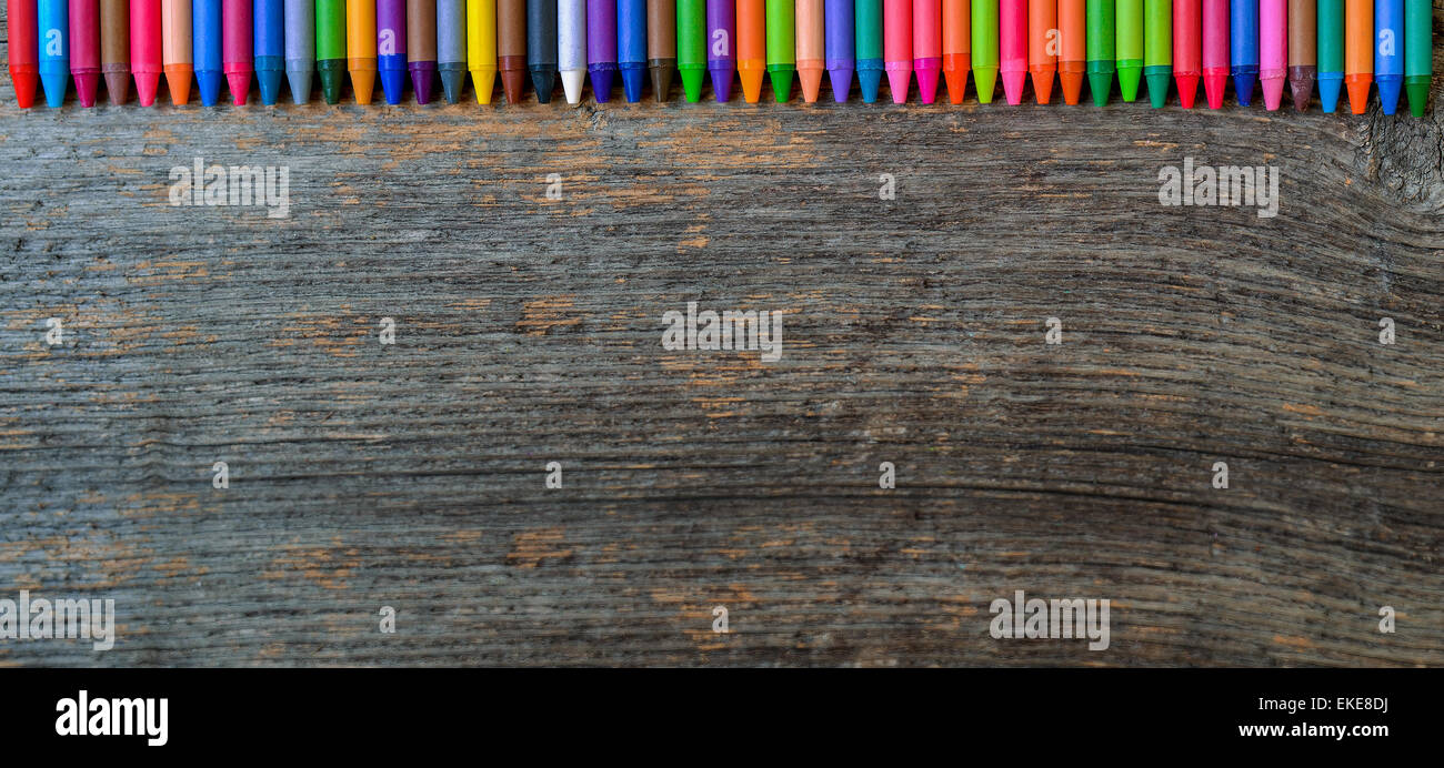 Des crayons alignés sur fond de bois Banque D'Images